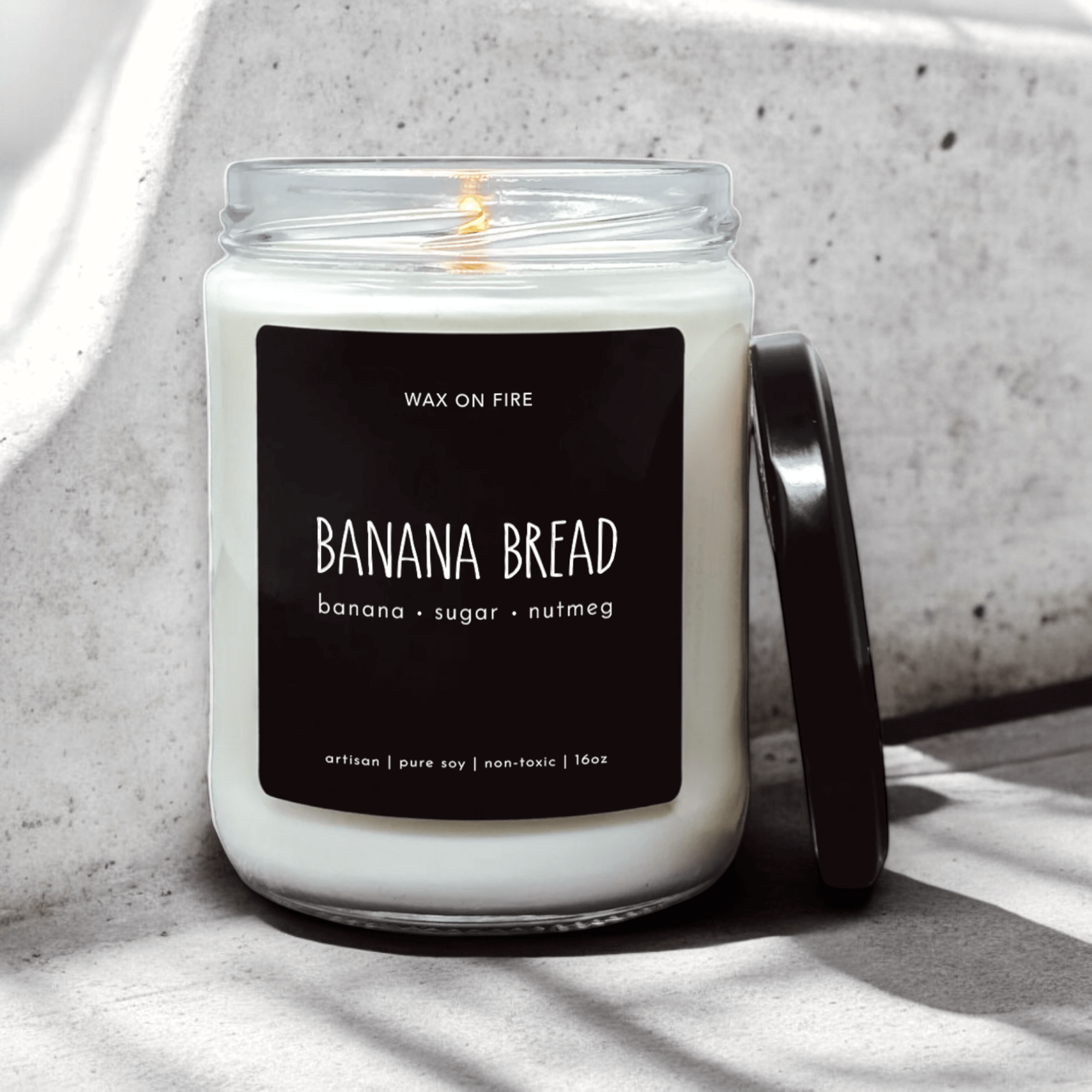 Banana Bread candle with notes of banana, sugar, and nutmeg in a clear glass jar, featuring a black label.