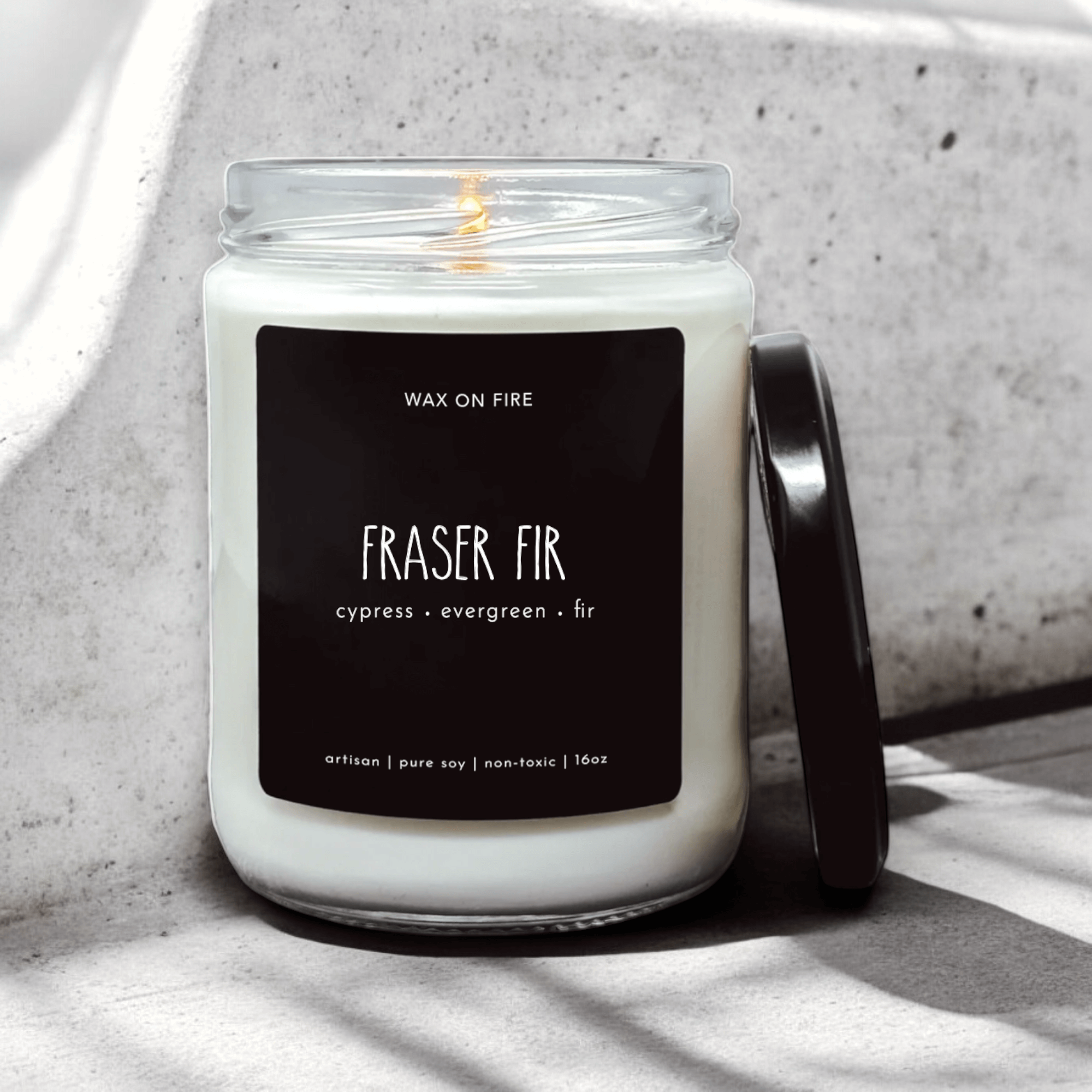 Fraser Fir candle in glass jar with wax on fire, featuring cypress, evergreen, and fir fragrance notes.