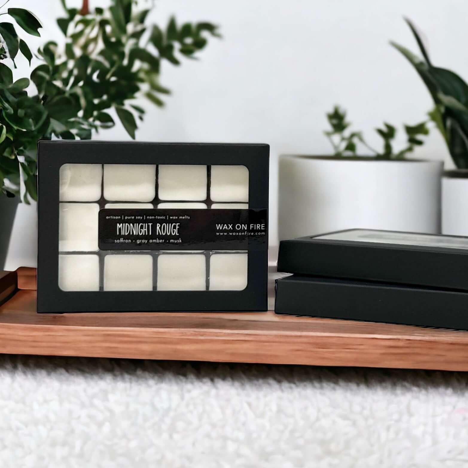 Non-toxic wax melts in a black box on a wooden surface, eco-friendly fragrance for a cozy home atmosphere.