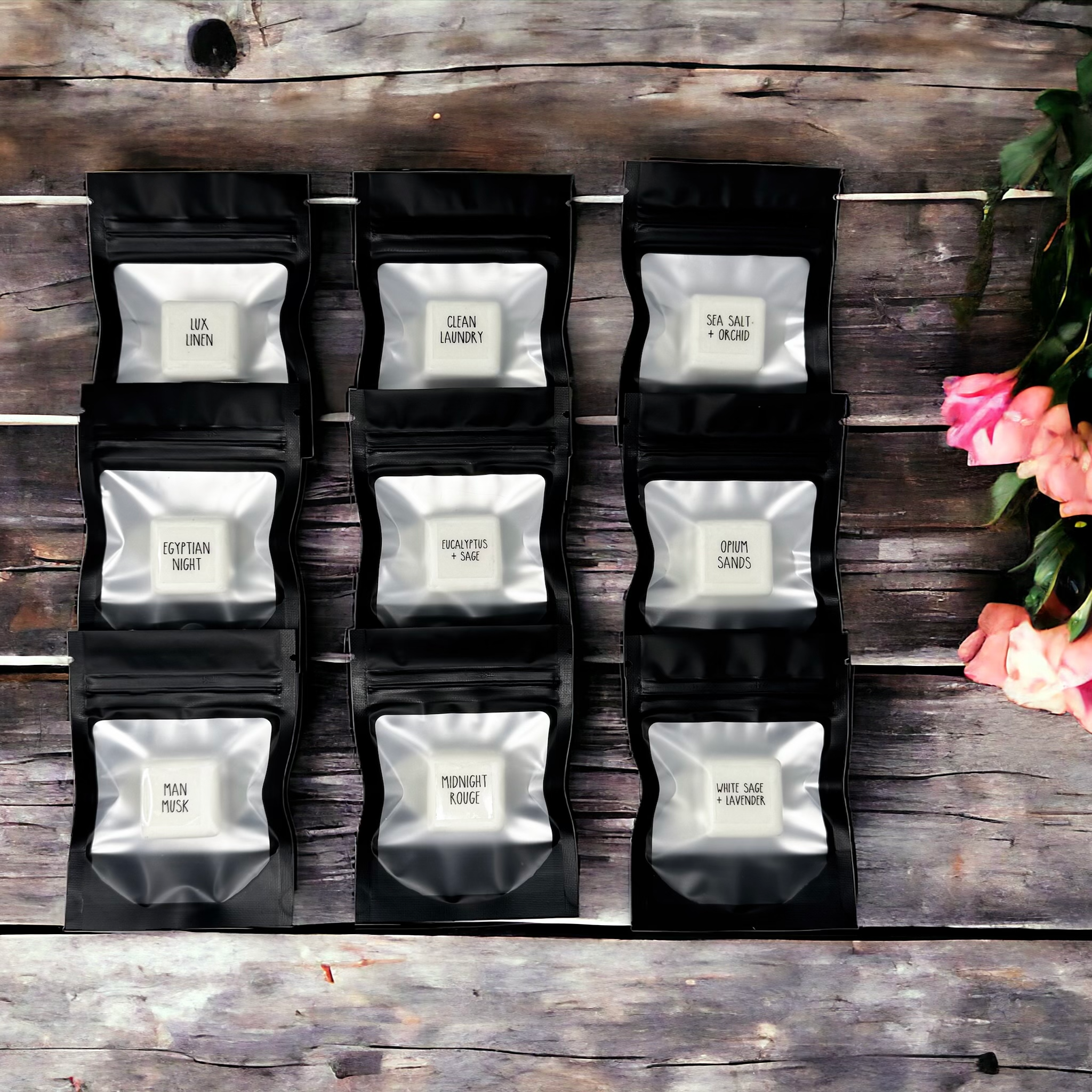 24-pack scent samples displayed in black bags on a wooden surface, featuring unique fragrance names.