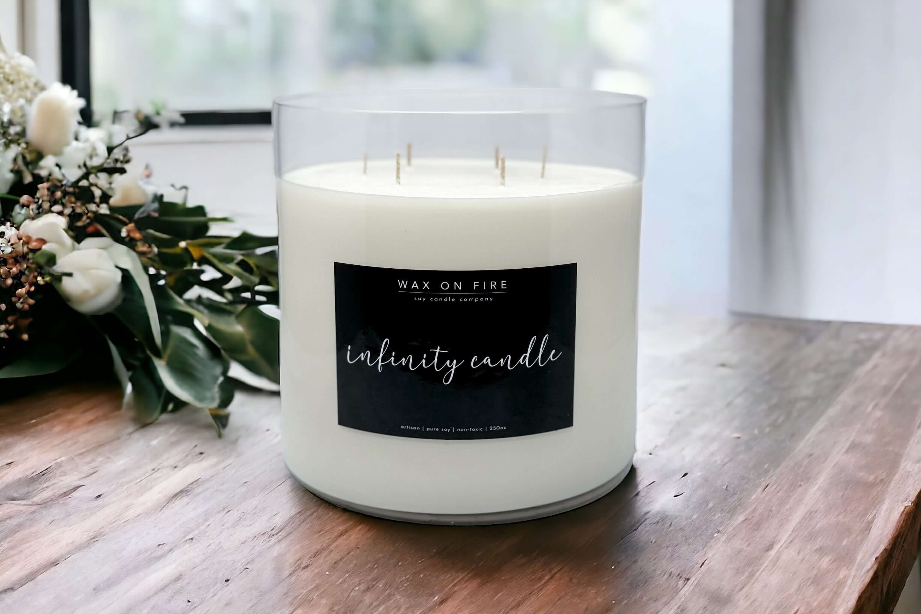 Artisan soy candle with a cream-colored wax and decorative flower, in a jar labeled 'Wax On Fire'.