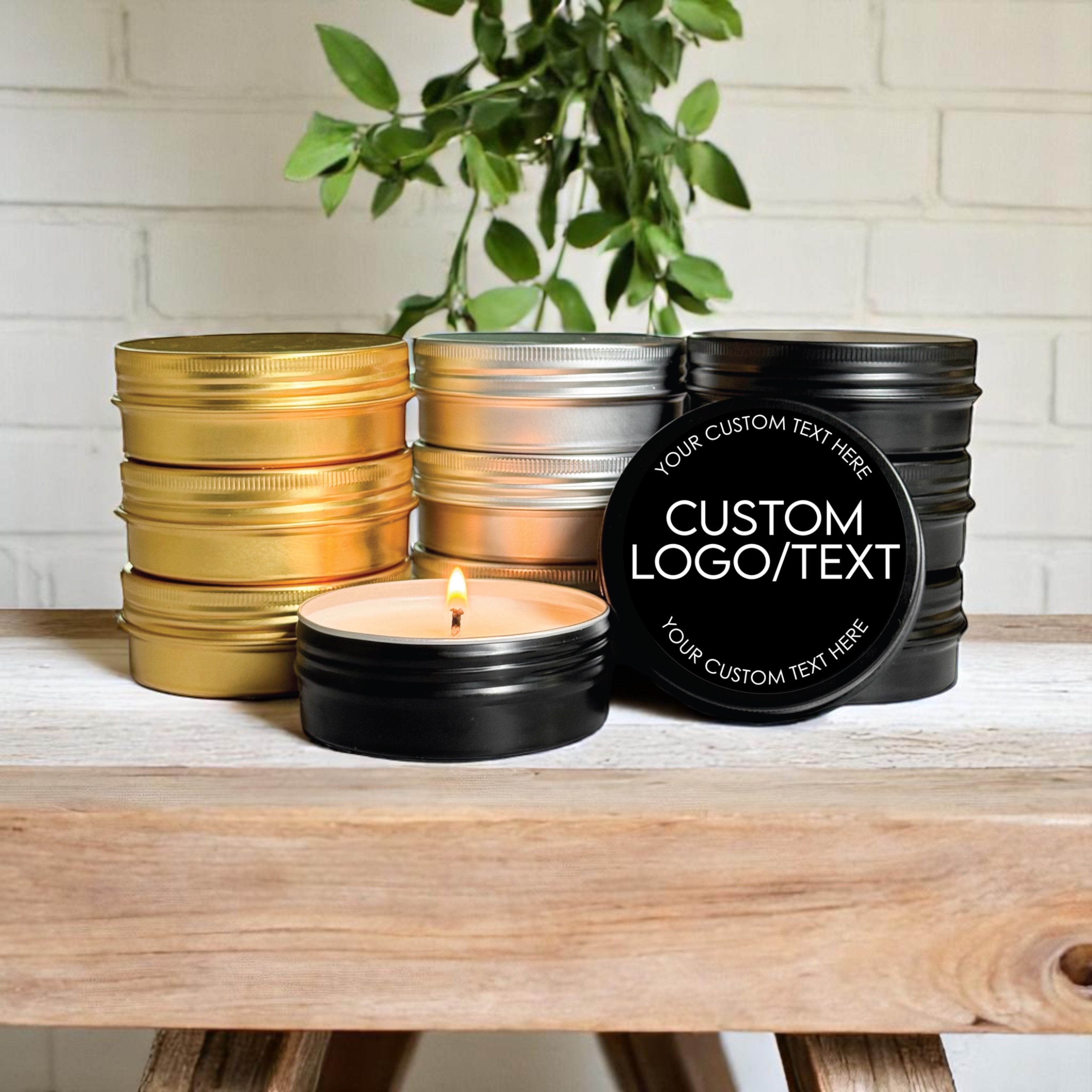 Bulk custom logo candle favors in gold, silver, and black tins on a wooden table, showcasing personalized labels.