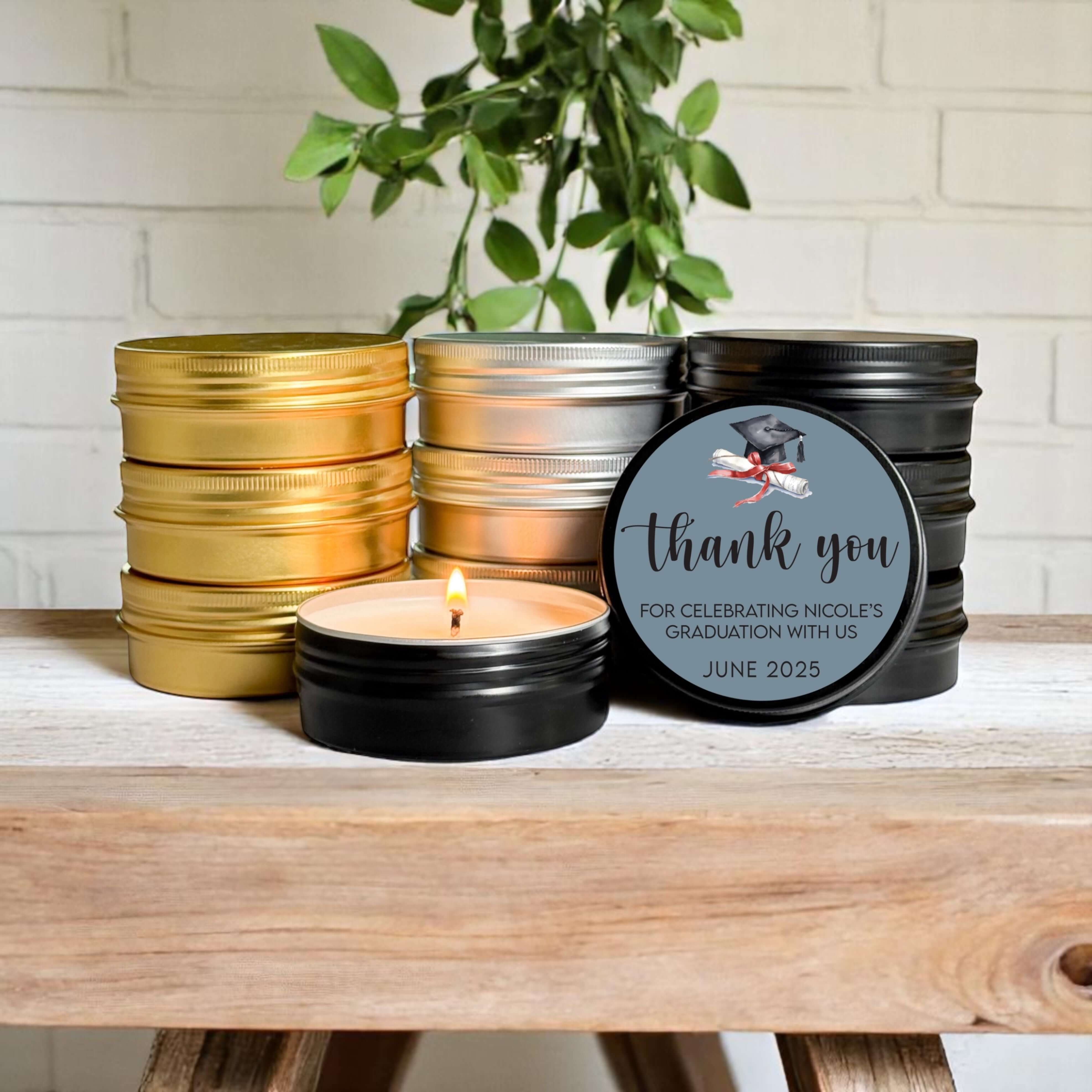 Bulk graduation favors featuring hand-poured candles in gold, silver, and black tins with customizable labels.