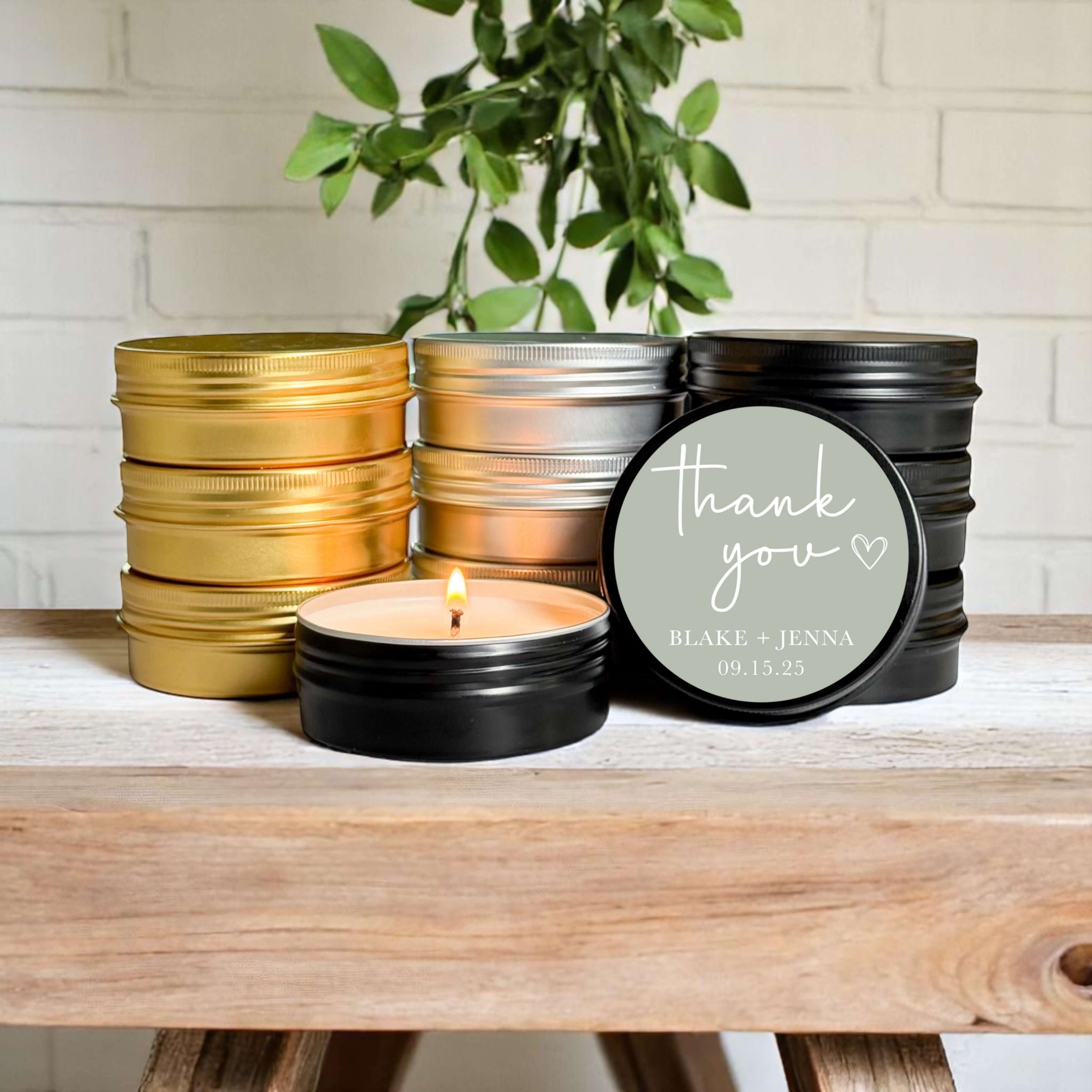 Bulk wedding favors featuring hand-poured soy candles in gold, silver, and black tins with customizable labels.